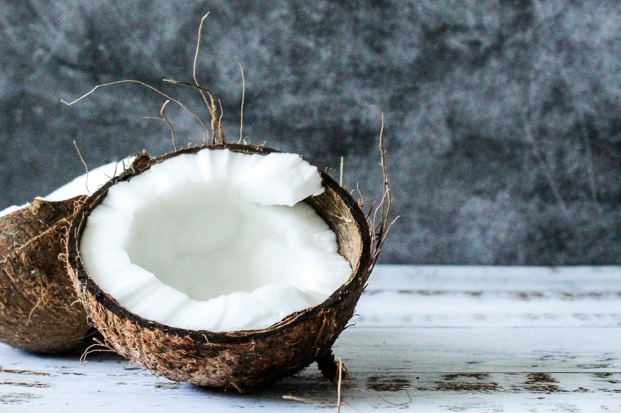 Discover the benefits of coconut candle wax as we have a coconut cut in half lying on a surface