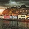 Colourful houses sit on front of the shore in Portree, the Isle fo Skye