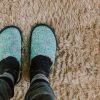 someone wearing slippers standing on a carpet after removing candle wax