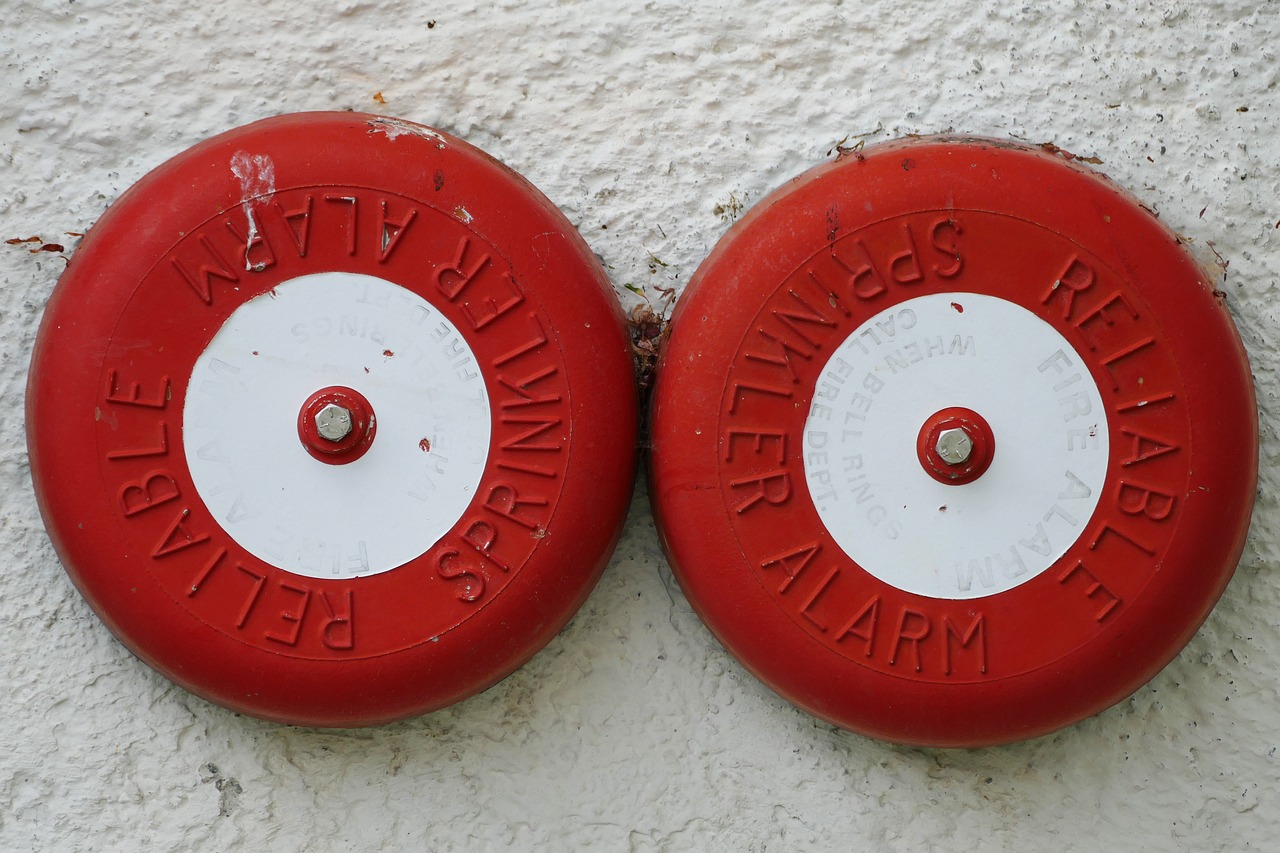 2 fire alarms on a wall together for a blog about will candles trigger fire alarms