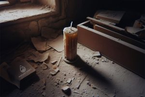 Do candles expire? A candle sits unlit in an abandoned floor building, in an extremely dusty setting. Some daylight shines through onto the candle
