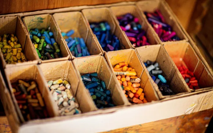 A box of used crayons with individual compartments for different colours. Can be used for adding colour to plain candles to turn into crayons, it is one idea about what to do with leftover candle wax.