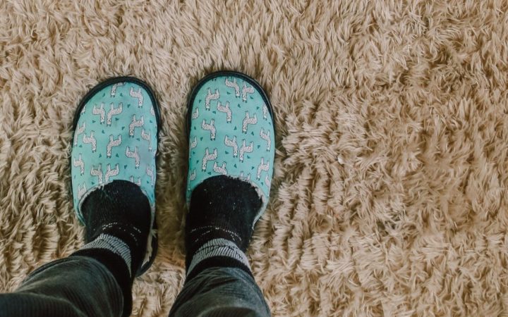 someone wearing slippers standing on a carpet after removing candle wax