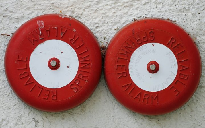 2 fire alarms on a wall together for a blog about will candles trigger fire alarms